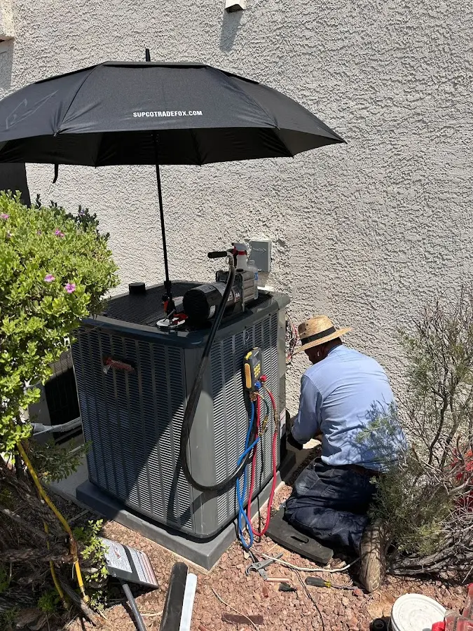 HVAC technician performing outdoor AC maintenance in Norman